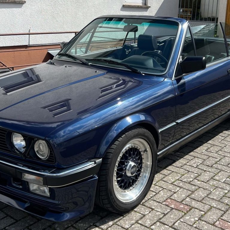 Oldtimerbewertung Nahaufnahme der Frontscheinwerfer eines klassischen Autos mit verchromtem Grill.
