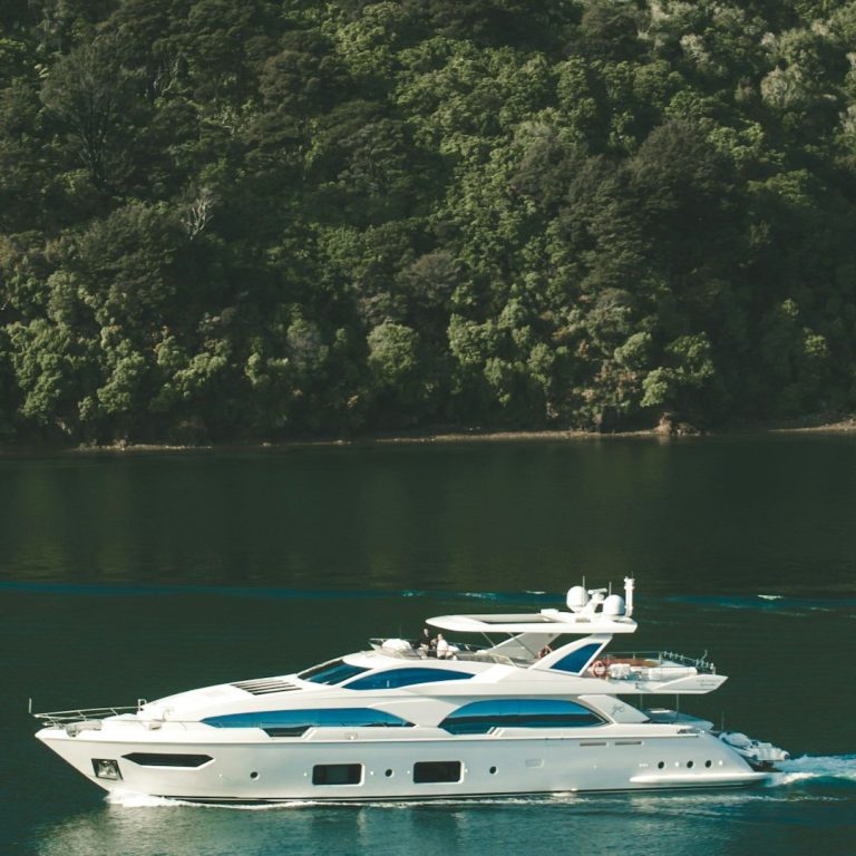 Ein elegantes Motorboot schifft ruhig auf glattem Wasser, umgeben von grüner Landschaft.