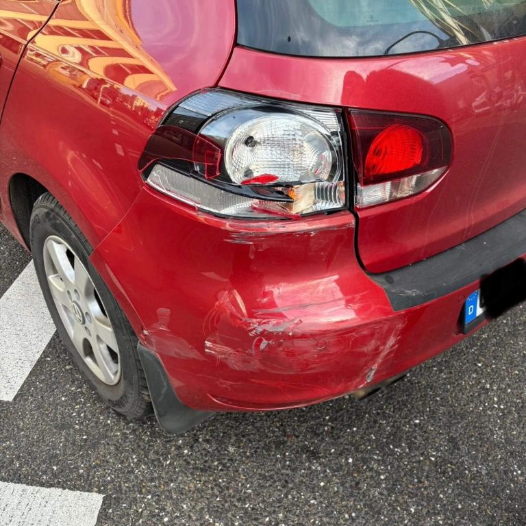 Kfz-Gutachten Ein schwarzer BMW fährt auf einer grünen, bewaldeten Straße.